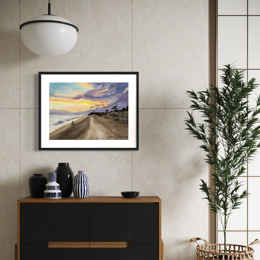 Framed artwork of a sunrise over an ocean beach scene with solitary person walking.