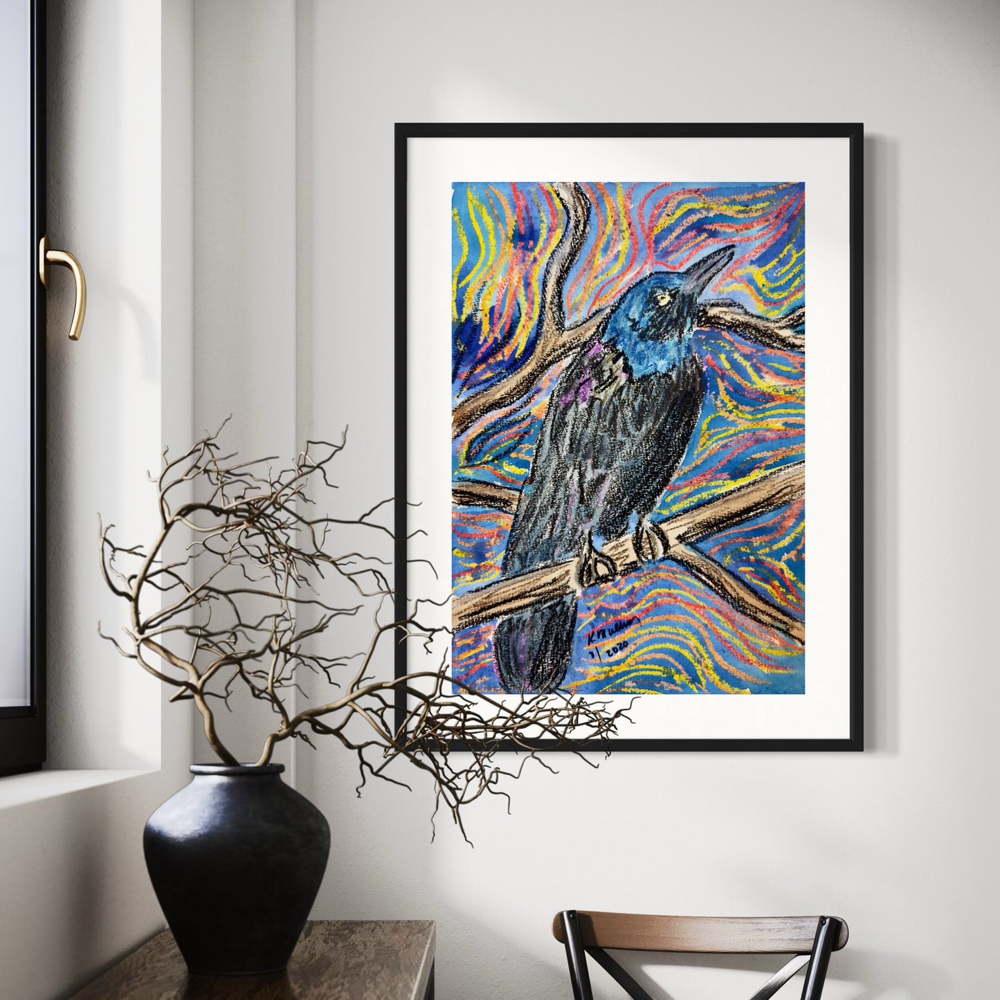 Framed mixed media artwork of a colorful crow bird on a branch in a room with decor elements.