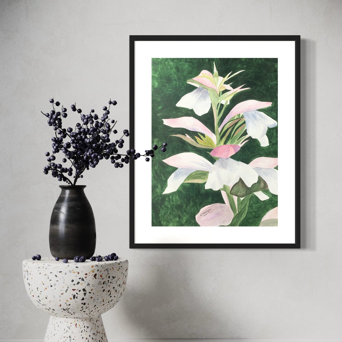 Framed watercolor floral artwork on a wall.