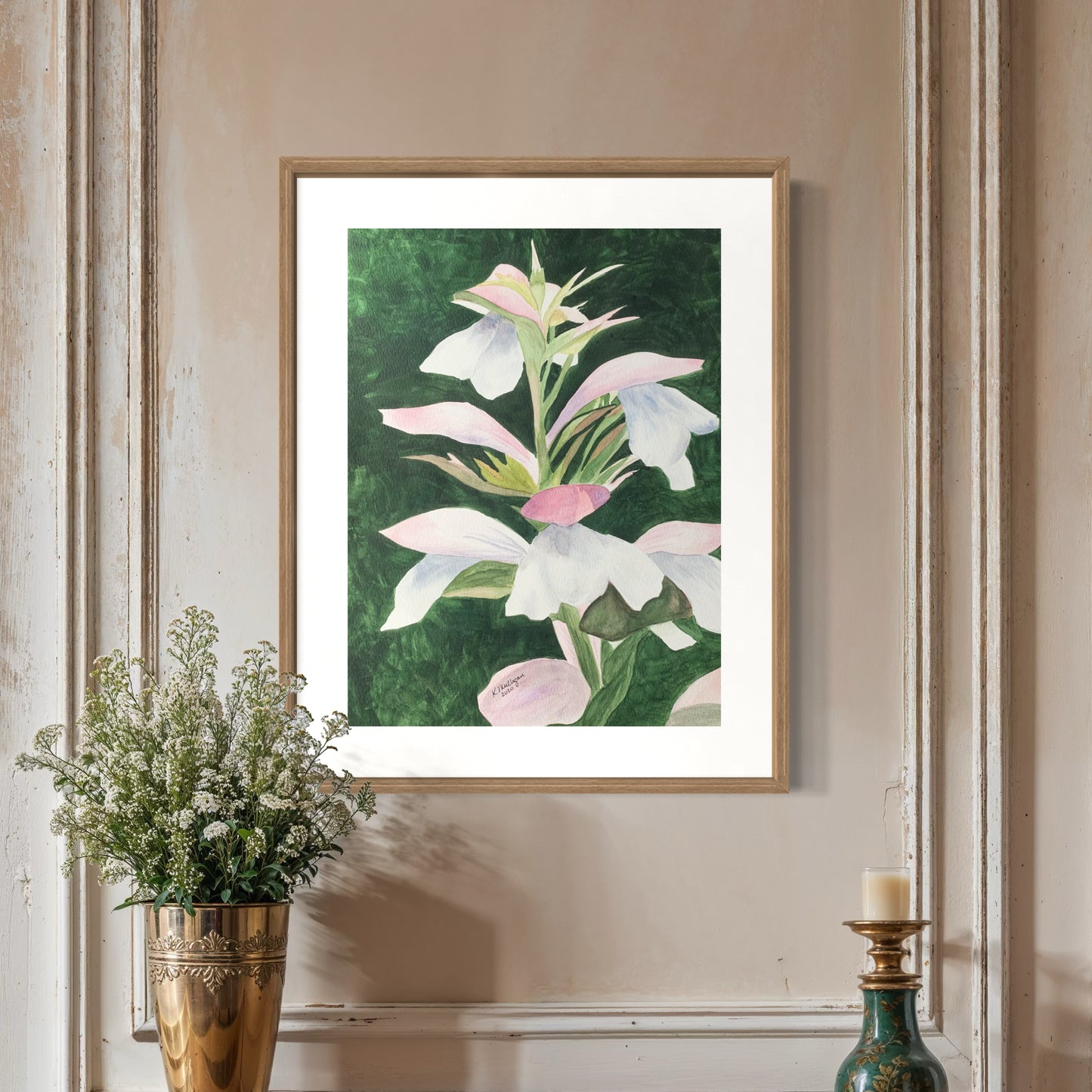 Framed watercolor pink and white floral artwork on a wall.