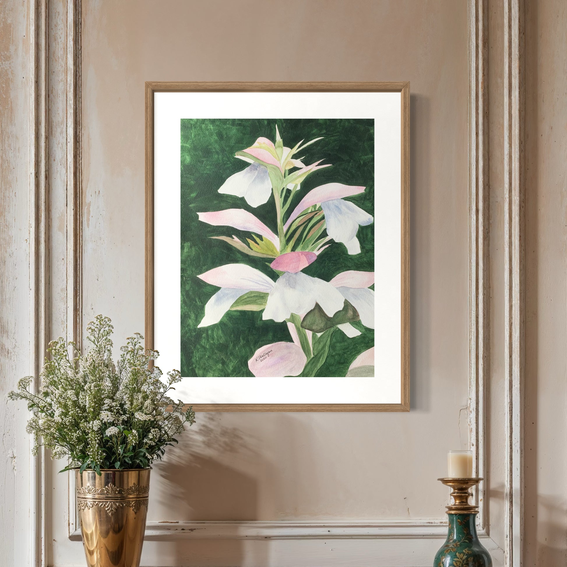 Framed watercolor pink and white floral artwork on a wall.