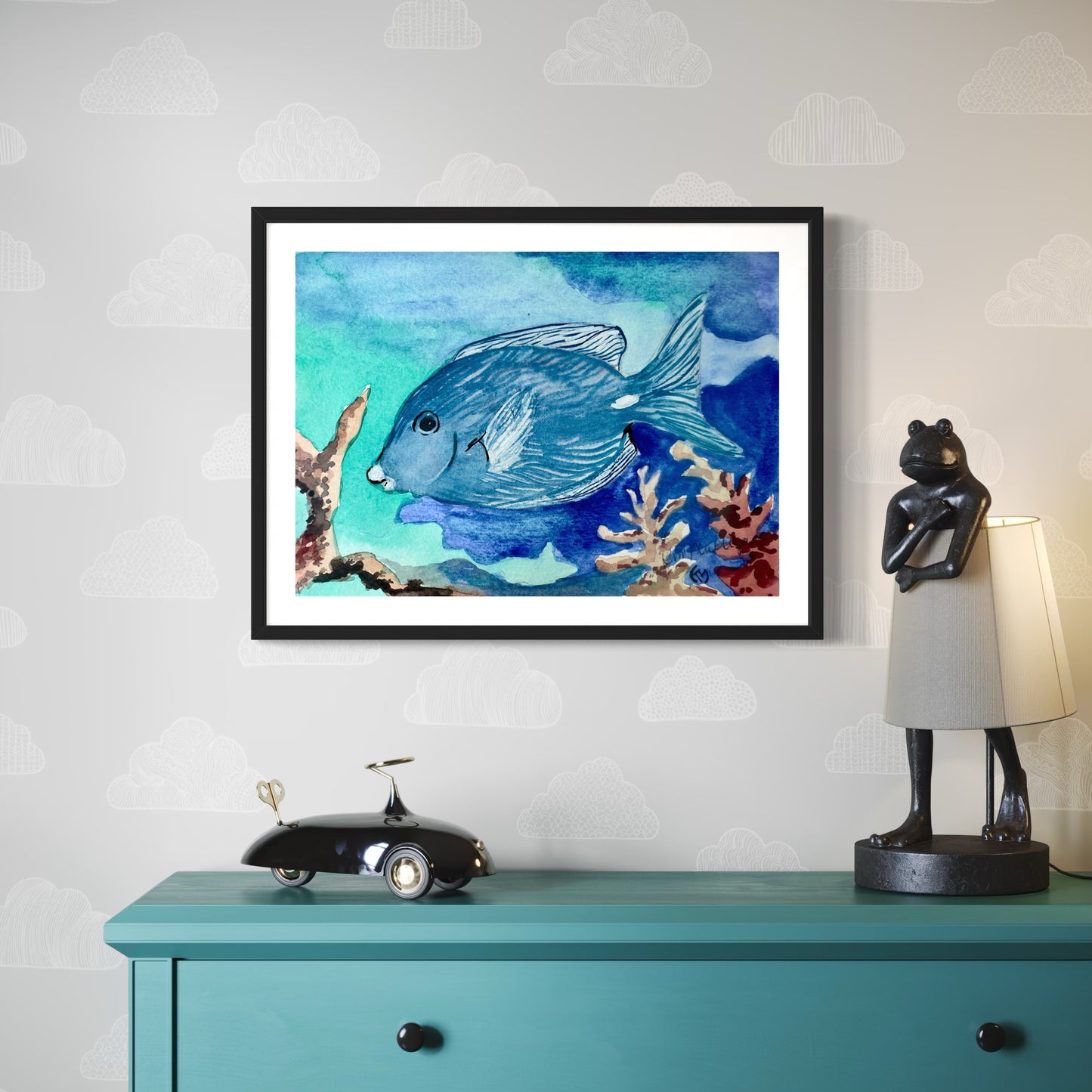 Framed artwork of a blue fish on a wall above a teal cabinet with decorative items.