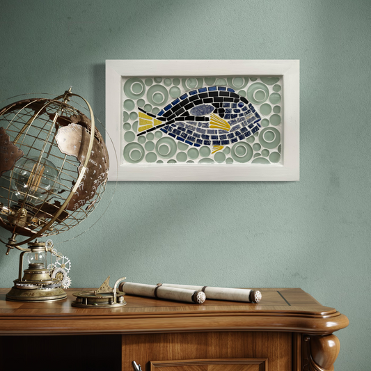 Framed mosaic artwork of a fish on a wall above a wooden desk with decorative items.
