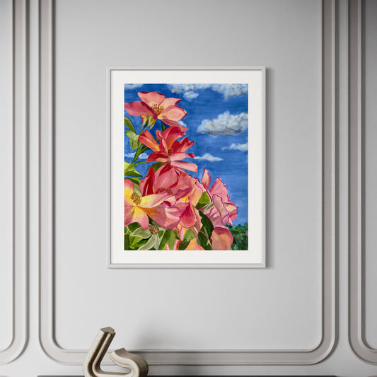 Framed artwork of pink roses against a blue sky on a gray wall.