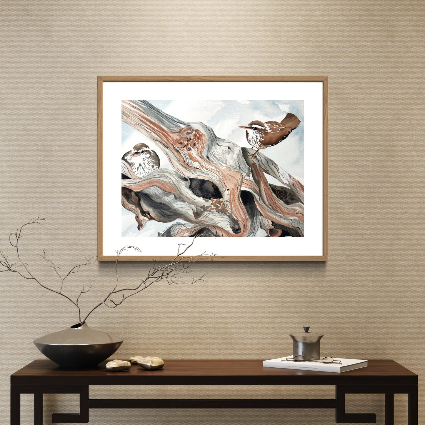 Framed watercolor painting of wrens on a dead log in the snow.