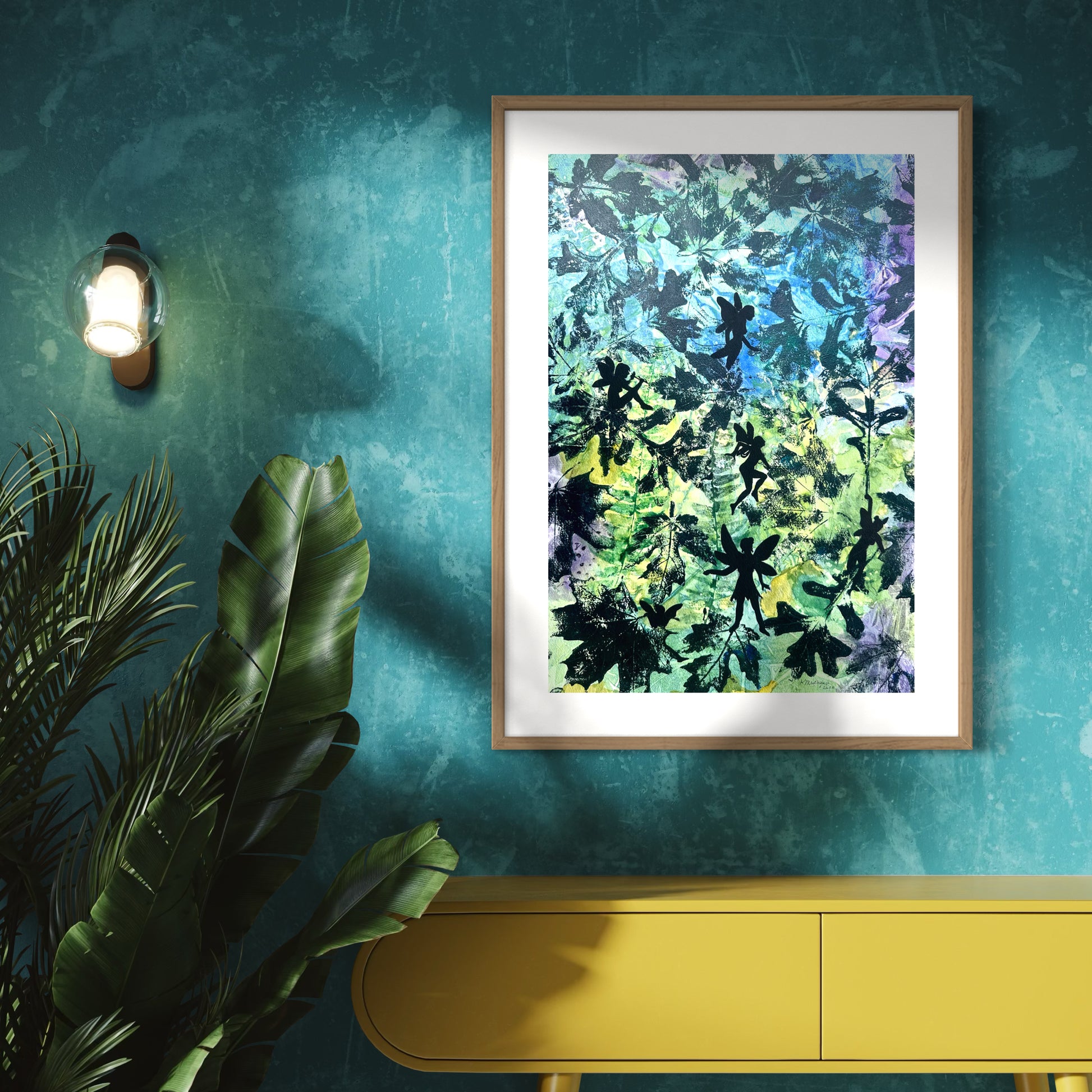 Framed abstract artwork of printed leaves with fairy silhouettes.