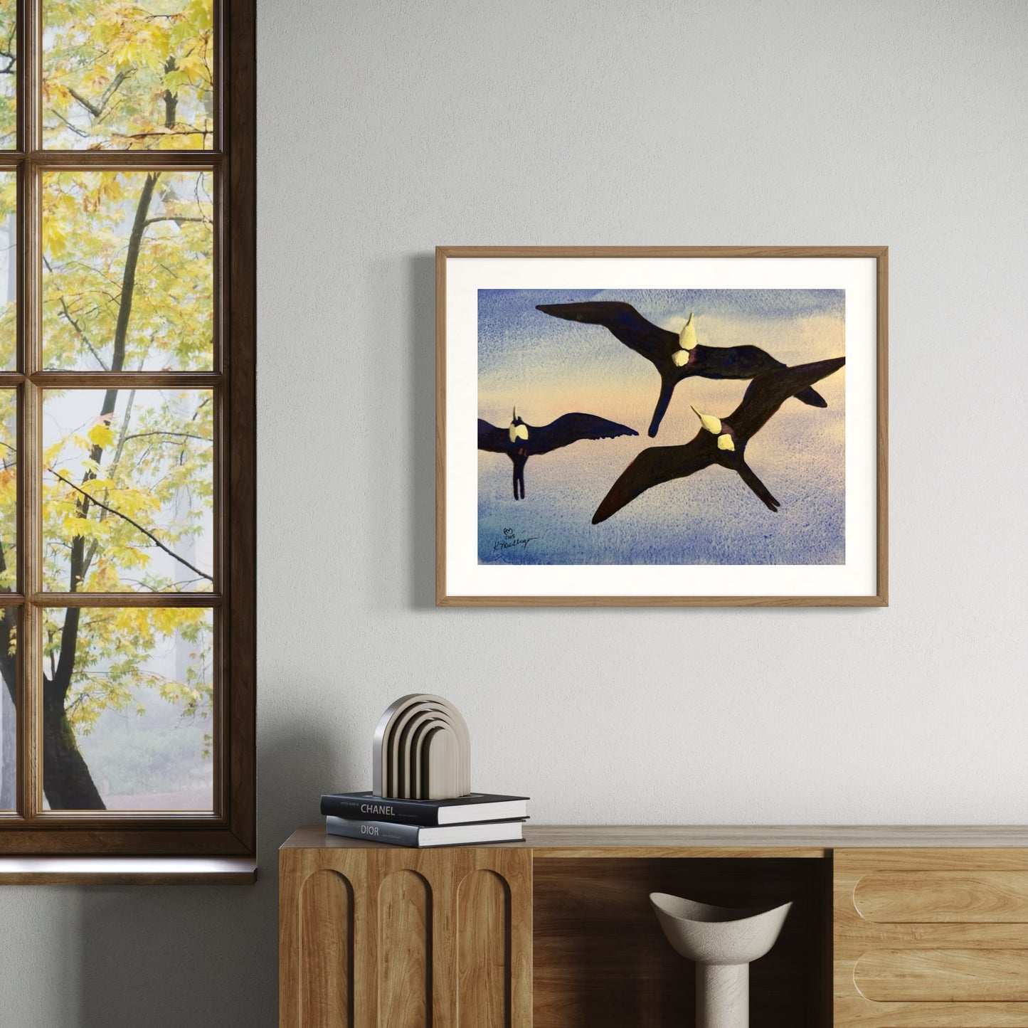 Framed Watercolor painting of three frigate birds flying against a textured blue and orange sky.
