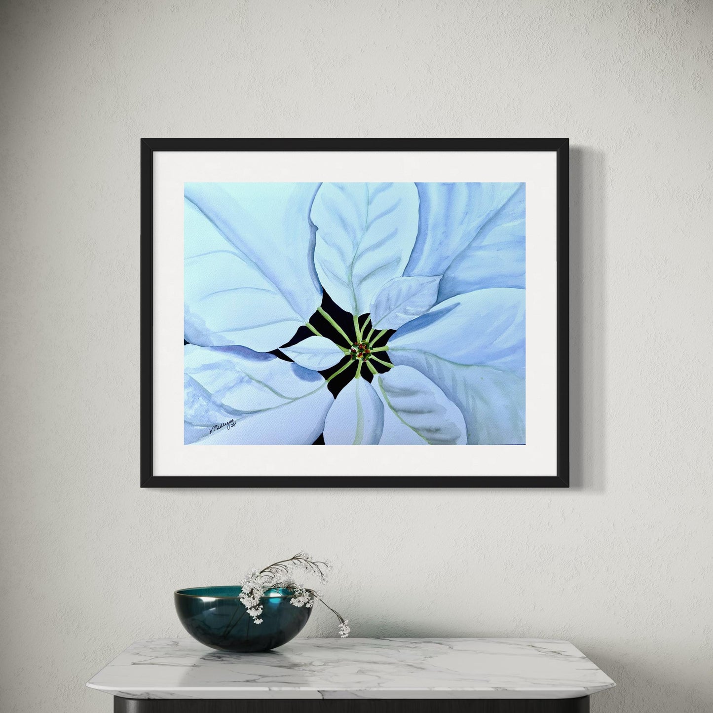 Framed watercolor painting of a close-up of a white poinsettia flower with green stems on a black center