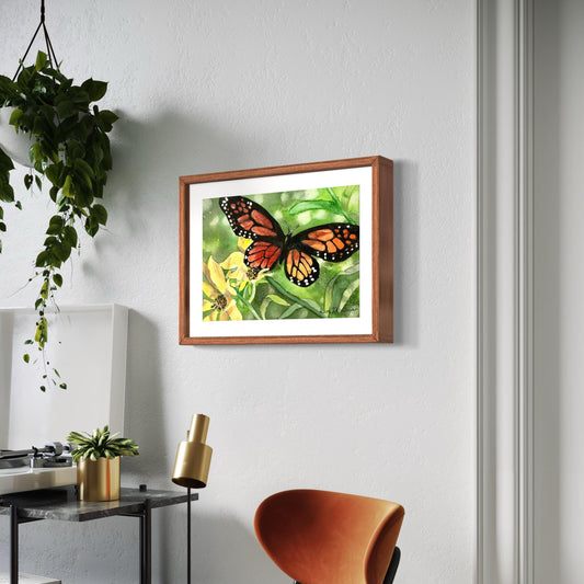 Framed watercolor painting of a black and orange monarch butterfly with yellow flowers and green leaves.