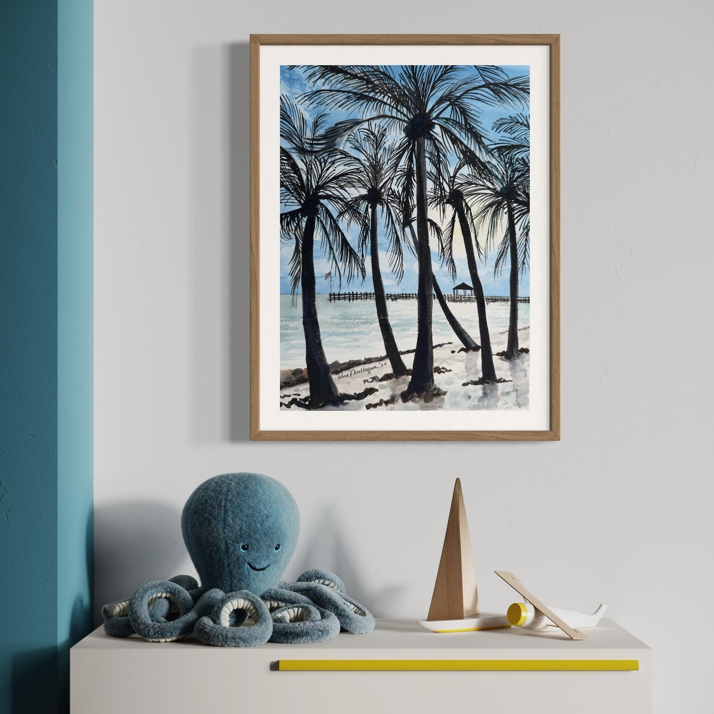 Framed watercolor painting of a beach scene with palm trees ocean and pier in the background.