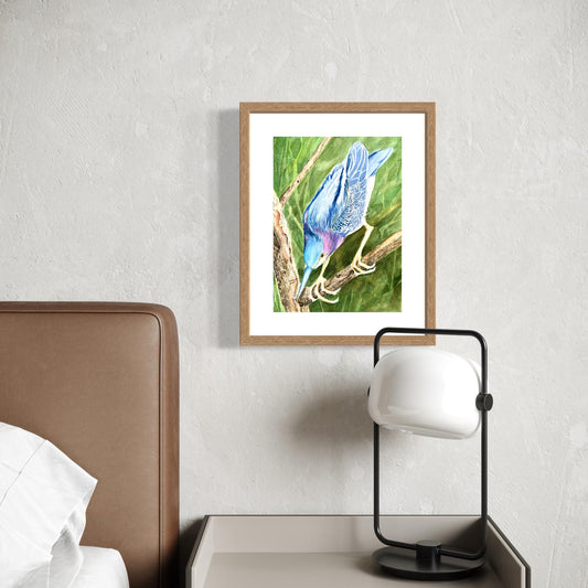 Framed watercolor painting a little green heron bird on a branch with muted leaves in the background.