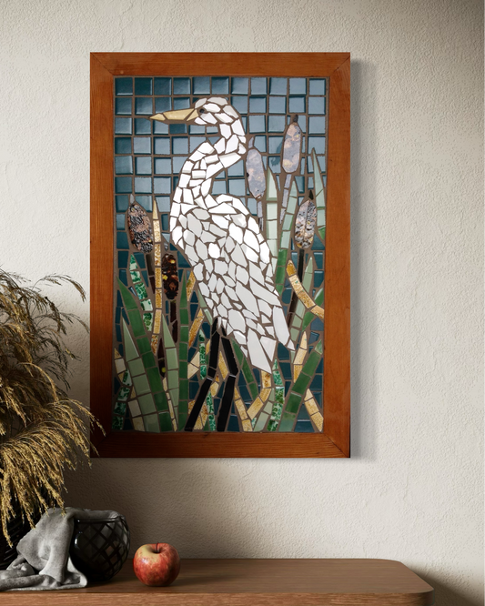 Mosaic artwork of a bird on a wall above a wooden console table.