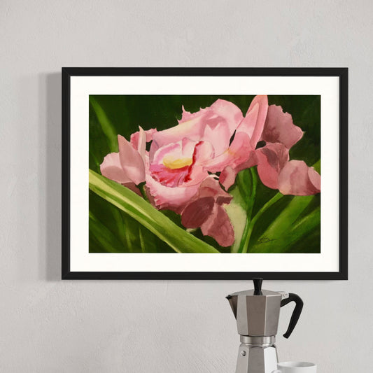 Framed watercolor artwork of pink iris flowers on a wall with a coffee maker below.