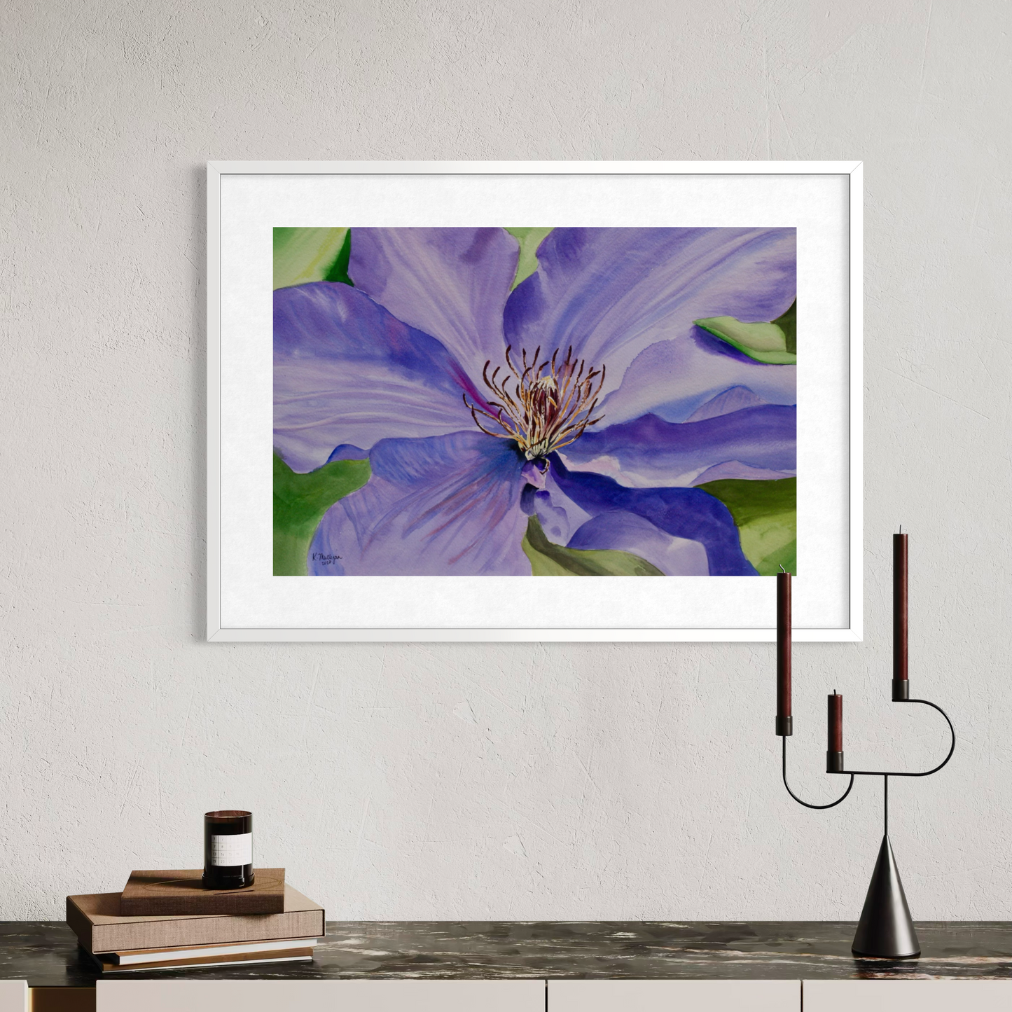 Framed watercolor artwork of a purple clematis flower on a wall above a console table.
