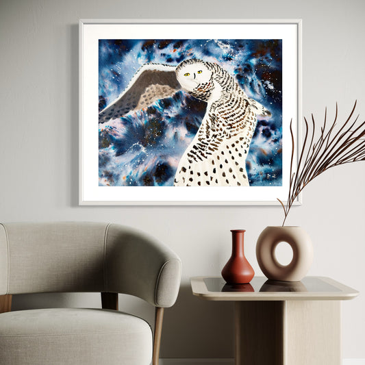 Framed watercolor artwork of a snowy owl against a cosmic sky.