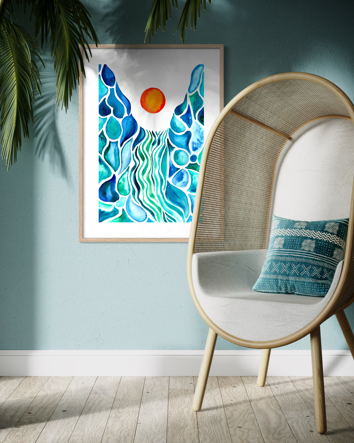 A framed abstract art print featuring blue and green wave-like forms with a small orange sun on a white background, displayed on a light blue wall next to a modern woven chair with a patterned pillow.