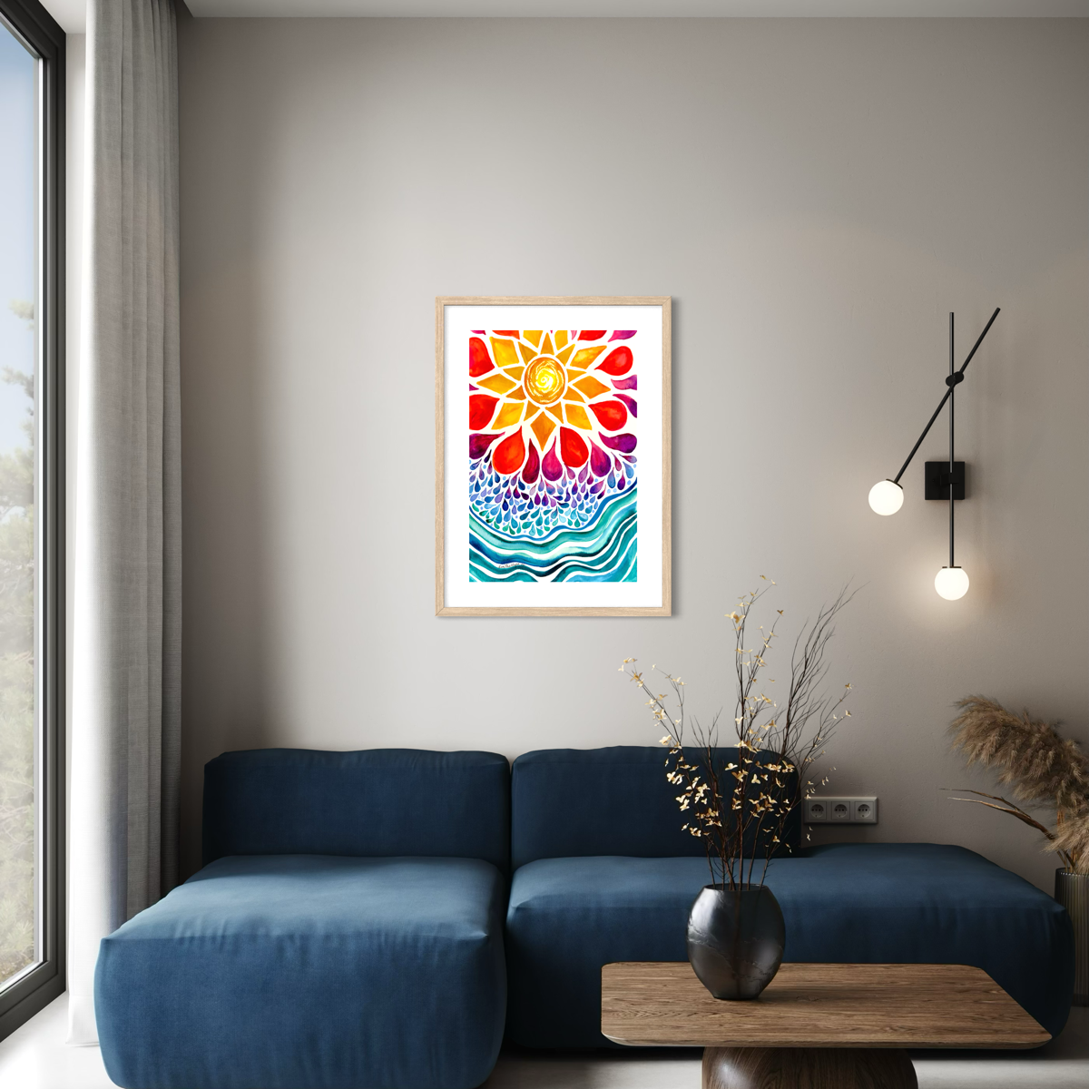 A framed colorful abstract floral wall art print hangs above a blue sectional sofa in a modern living room setting with a wooden coffee table, black wall sconces, and a vase with dried branches.