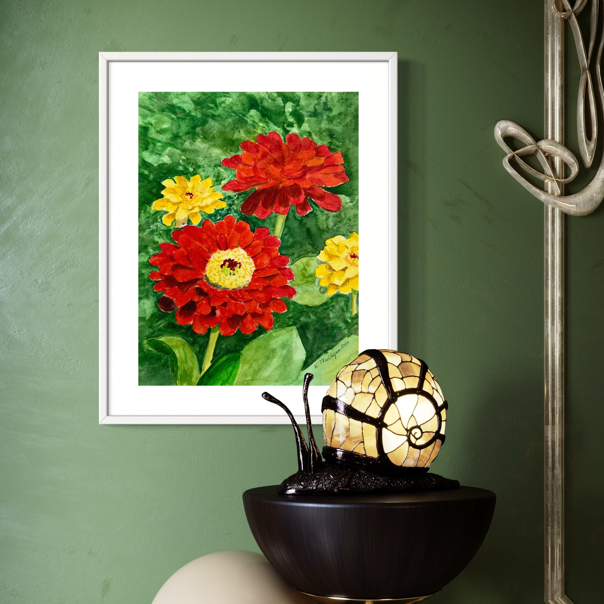 Framed watercolor painting of yellow and red zinnia flowers with green leaves.